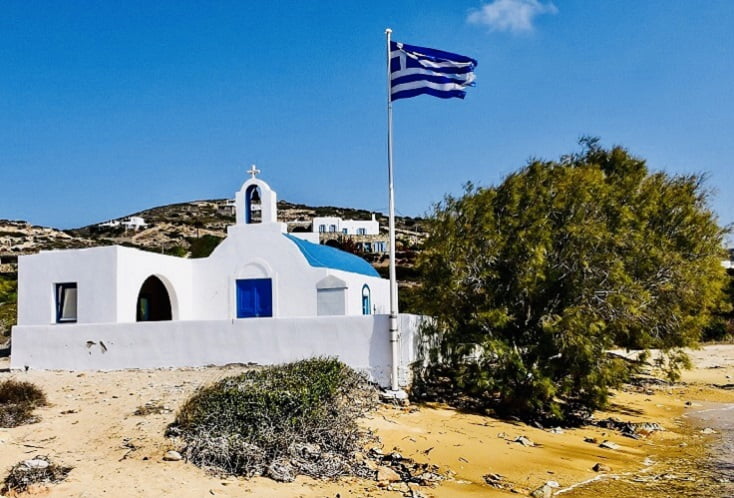 Praia de Agios Georgios com a igreja homônima, que já sediou casamentos de celebridades.