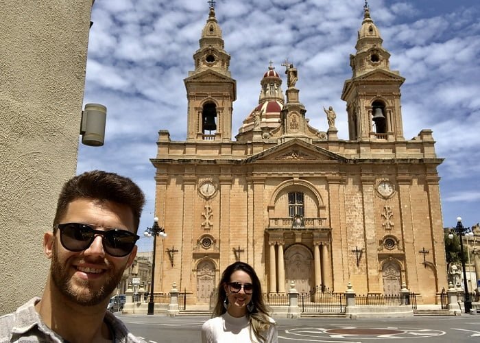 igreja de Luqa, em Malta, com os ponteiros dos dois relógios mostrando horas diferentes.