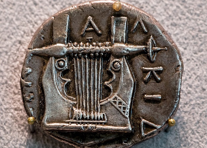 Cítara grega e moeda da Grécia Antiga.