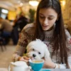 Mulher com café e cachorro.