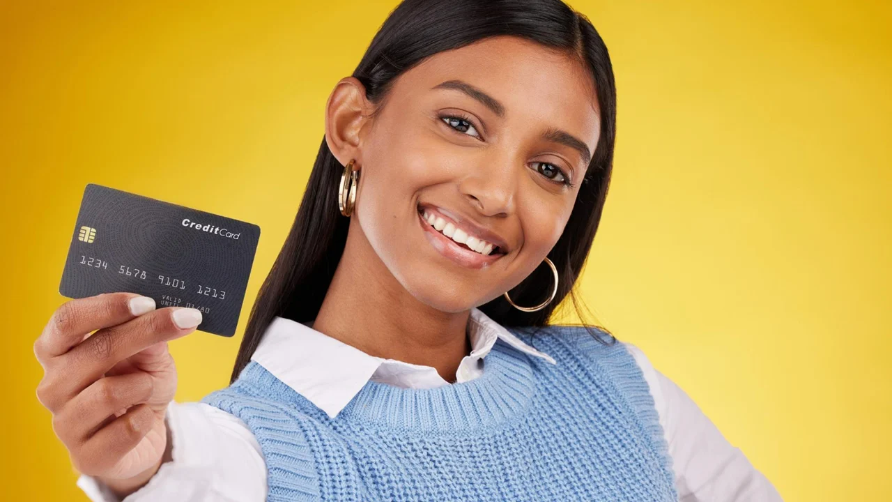 Mulher mostrando o cartão de crédito.