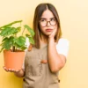 Mulher em dúvida com plantas.