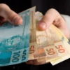 Dinheiro nas mãos de um homem de terno.