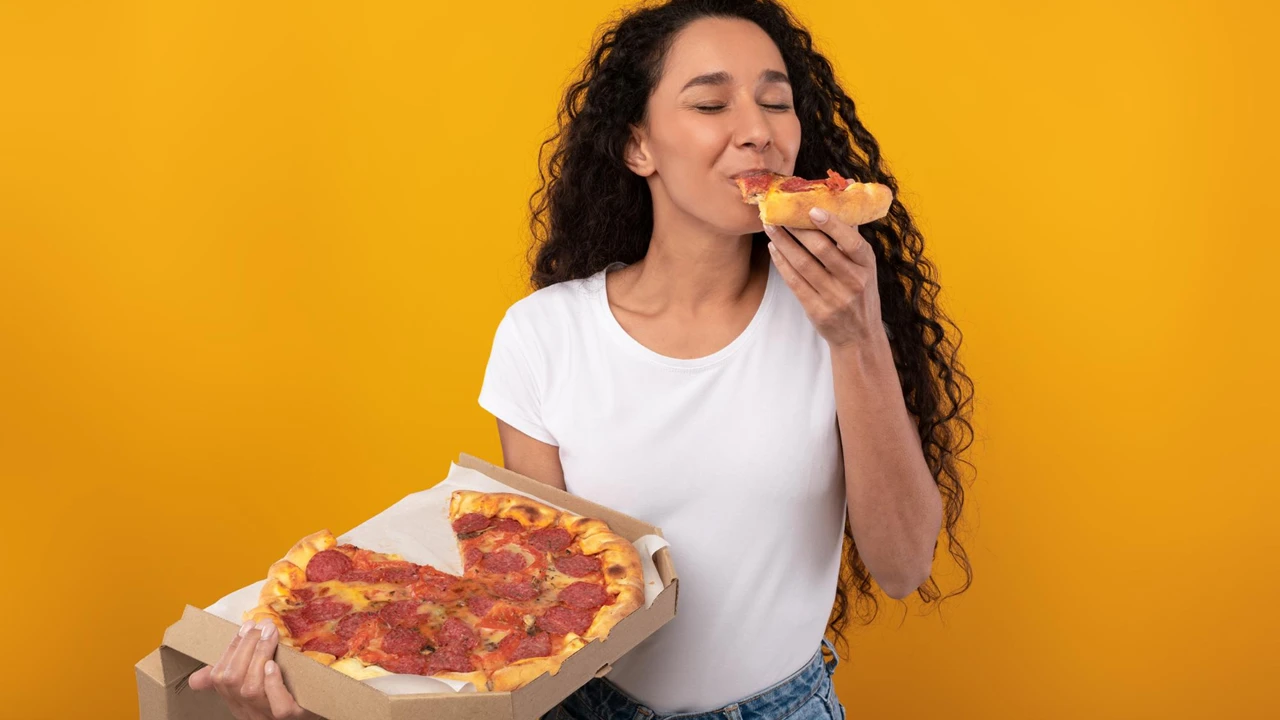 Mulher comendo pizza.
