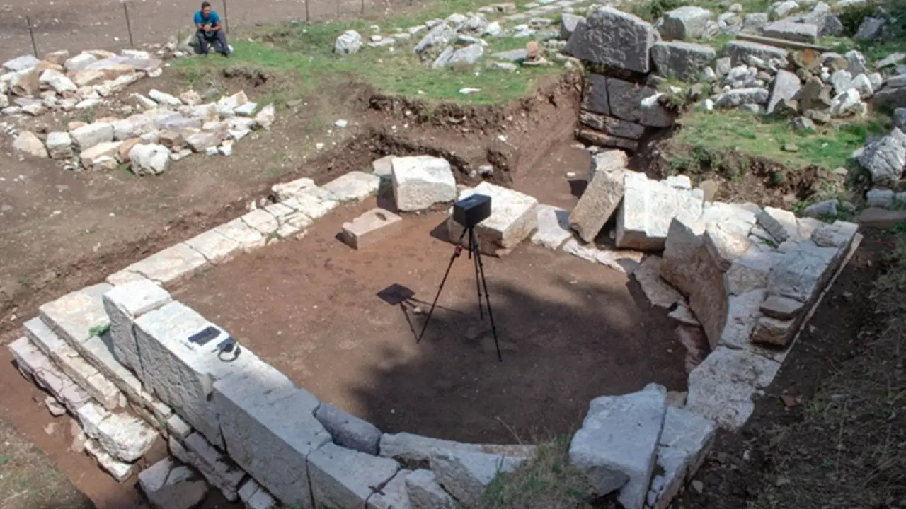 Edifício escavado com parede interior circular de pedra no Santuário de Zeus, alto-falante colocado no ponto focal da curva. Crédito: Pamela Jordan
