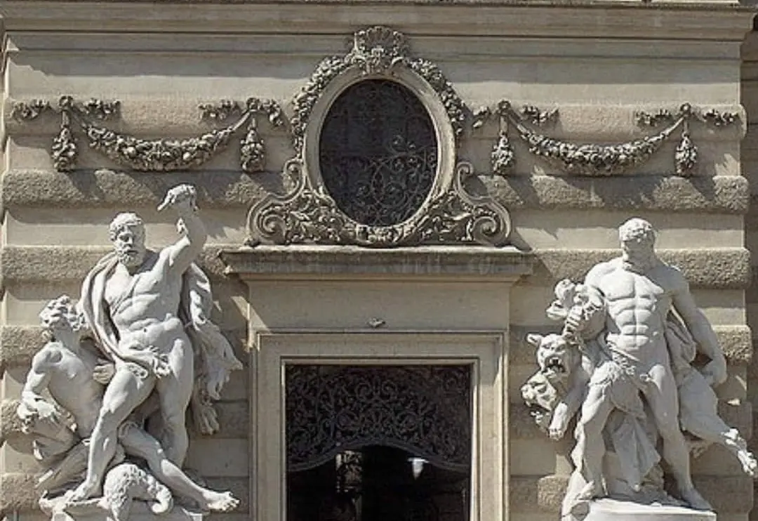 A estátua de Hércules e Cérbero na representação original está localizada no Palácio Hofburg em Viena.
