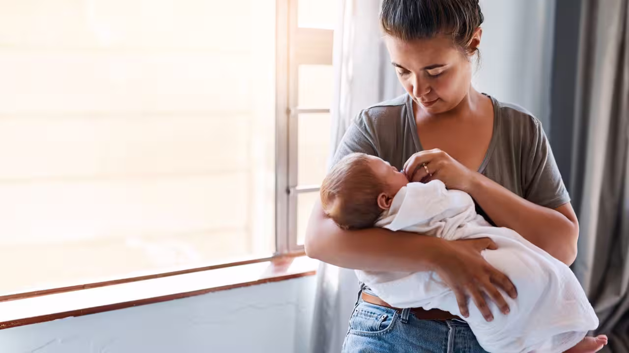 Mãe com bebê no colo.