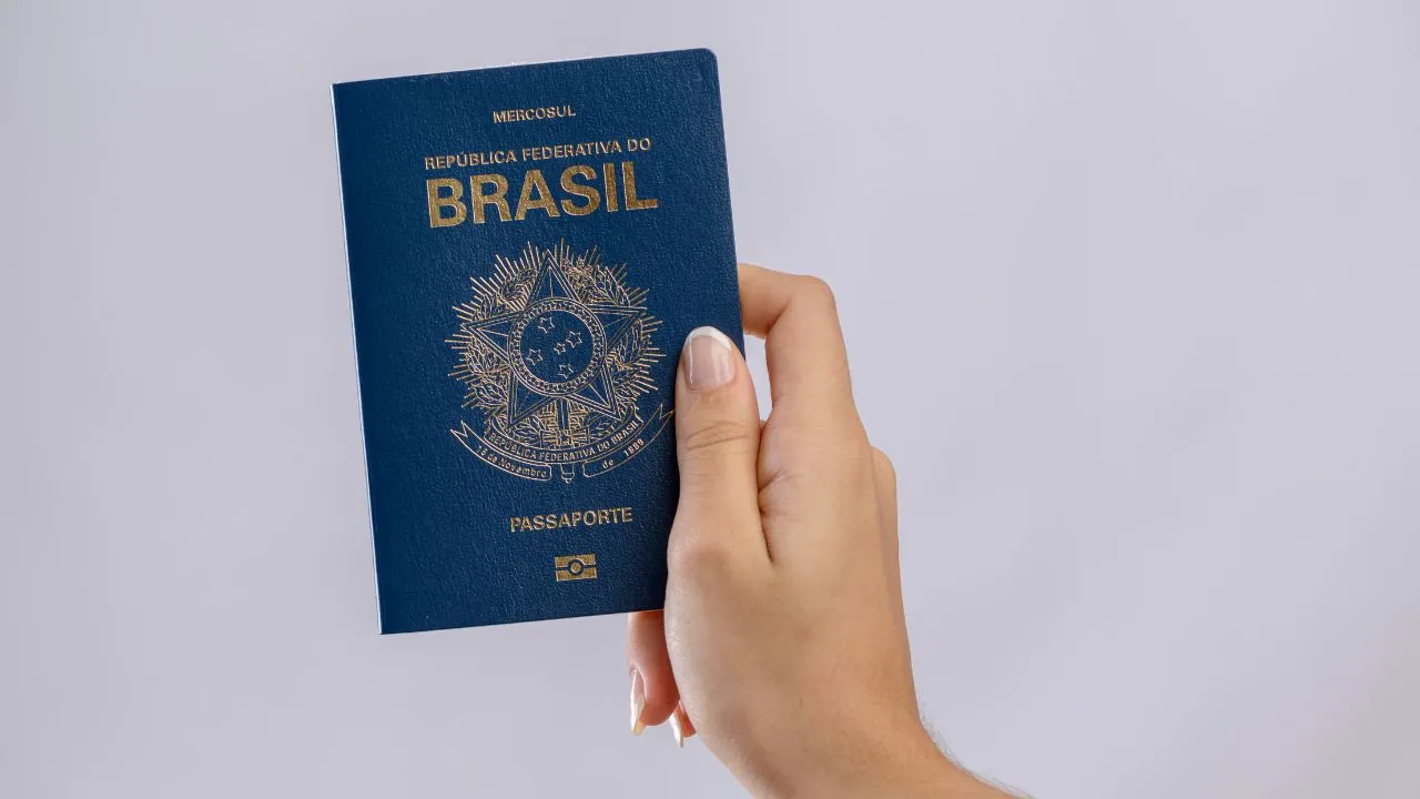 featured_img Pessoa segurando passaporte brasileiro.